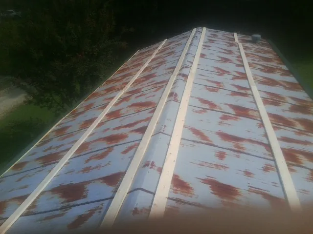 Rusted metal roof panels with new wood purlins before replacement — Storm Damage Roof Repair in Bitely by Roofing Brothers